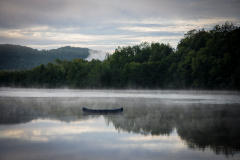 Landscape of calm water surface and fog in Mont Tremblant in Canada in morning.